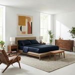 Deep ink blue duvet adds bold contrast and cozy elegance to a warm, minimalist bedroom