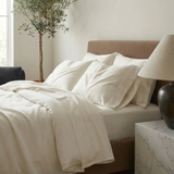 Luxe pillowcases in stone add quiet sophistication to a serene, light-filled sleep space